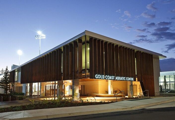Modern exterior of Gold Coast Aquatic Centre at dusk—an ideal stop on relaxed Gold Coast tours for families, offering Olympic pools, splash zones, and indoor facilities just minutes from Broadwater Parklands.